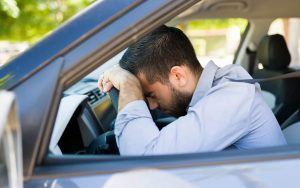 Uomo disperato al volante di un'auto