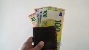 Uomo con un portafoglio pieno di banconote euro