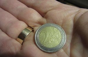 mano con moneta da 2 euro