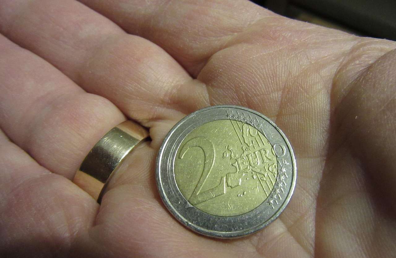 mano con moneta da 2 euro