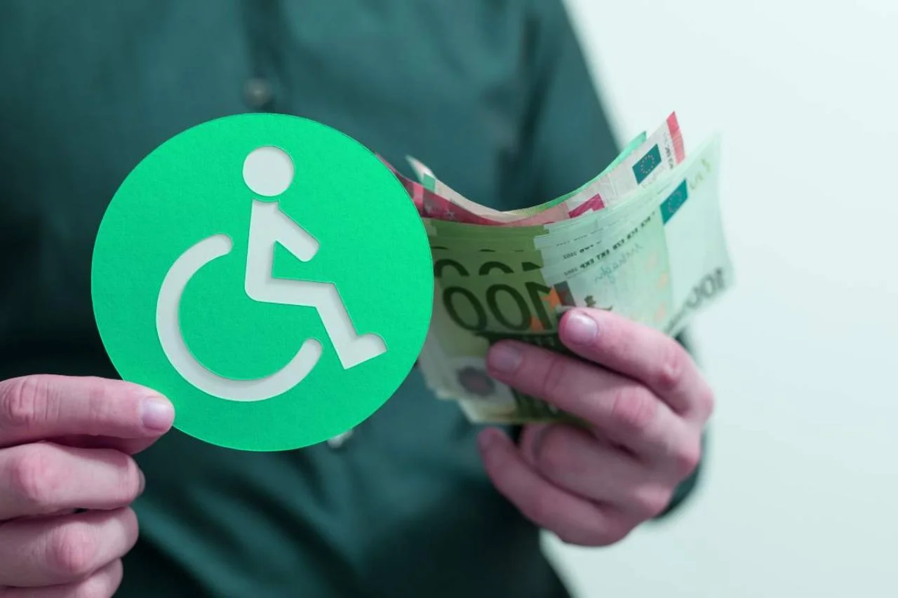 Uomo con banconote euro e bollino "disabilità" in mano
