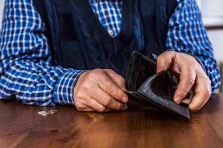 Pensionato che si guarda il portafoglio vuoto
