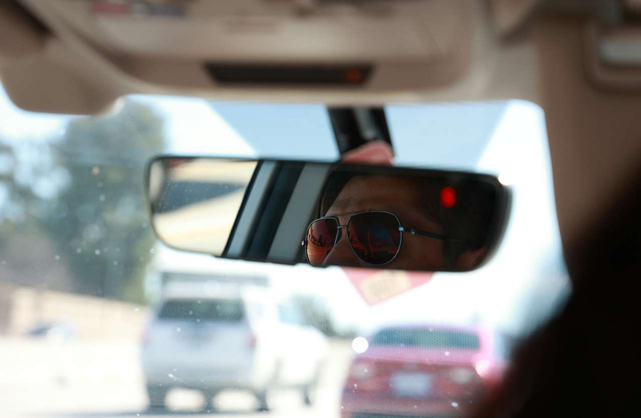 uomo in macchina con occhiali da sole